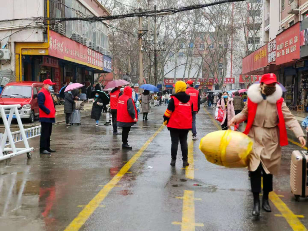 2、志愿者教师冒雨协助维持秩序.jpg