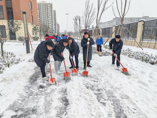 教师志愿者分工协作,有的铲雪破冰,有的清扫残雪.jpg